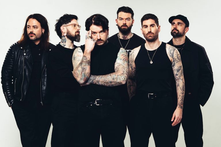 UK metalcore band Bury Tomorrow posing together in dark clothing against a plain background for a promo photo shoot.